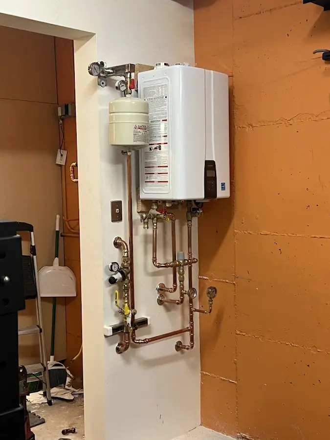Plumbing technician inspecting water heater connections in North Brunswick